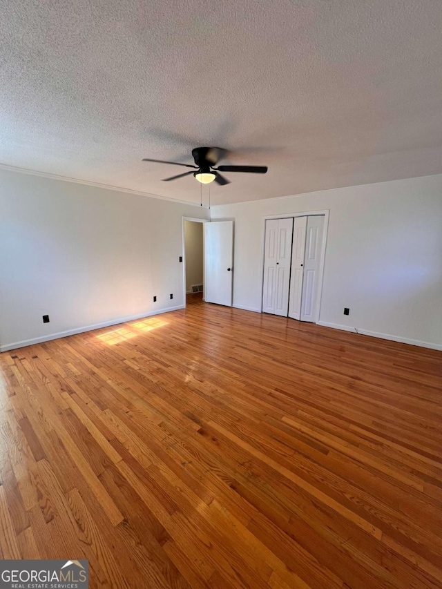 unfurnished bedroom featuring ceiling fan, a textured ceiling, and light hardwood / wood-style flooring