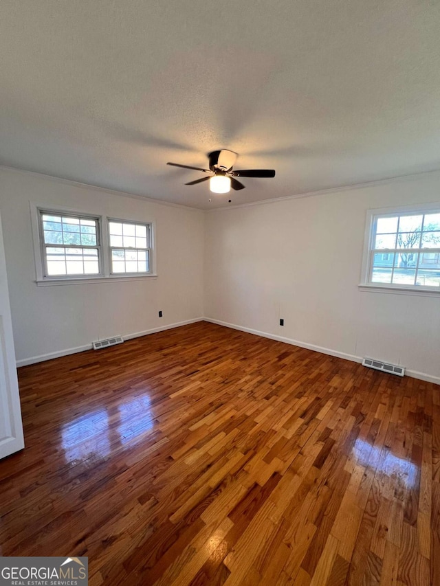 spare room featuring hardwood / wood-style floors, a textured ceiling, ceiling fan, and ornamental molding