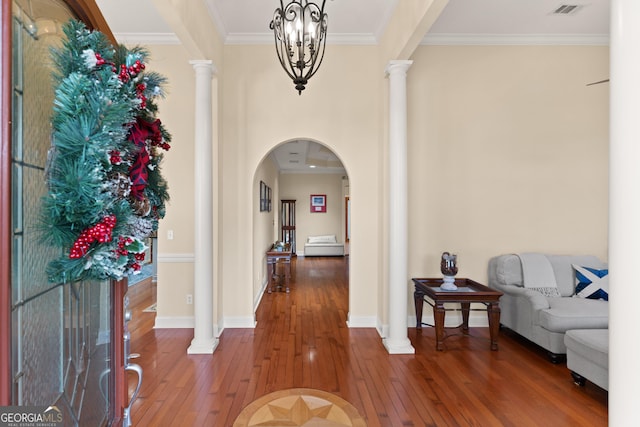 entryway with hardwood / wood-style floors, an inviting chandelier, and crown molding