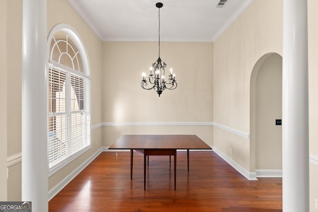 unfurnished dining area featuring a notable chandelier, dark hardwood / wood-style flooring, and ornamental molding