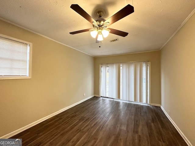 empty room featuring ornamental molding, ceiling fan, and dark wood-type flooring