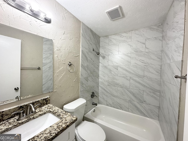 full bathroom with vanity, tiled shower / bath, a textured ceiling, and toilet