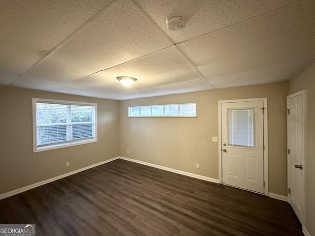 foyer with dark hardwood / wood-style flooring, a paneled ceiling, and plenty of natural light