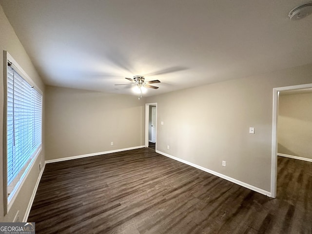 empty room featuring ceiling fan and dark wood-type flooring