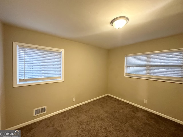 carpeted spare room featuring plenty of natural light