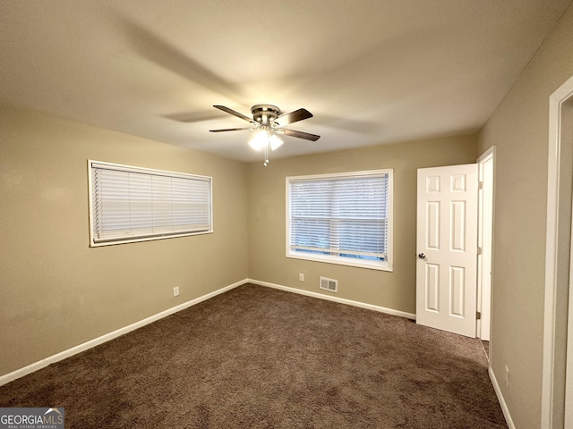 carpeted spare room featuring ceiling fan