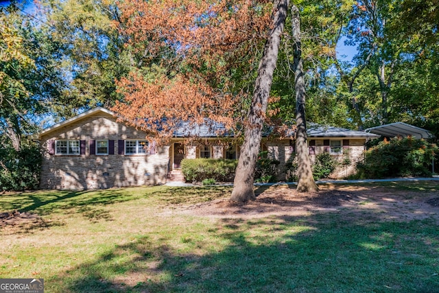 ranch-style house featuring a front yard and a carport