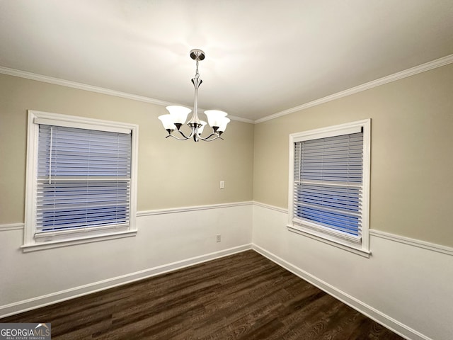 spare room with dark hardwood / wood-style flooring, crown molding, and a chandelier