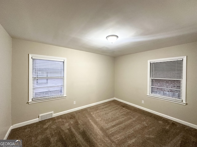 unfurnished room with dark carpet