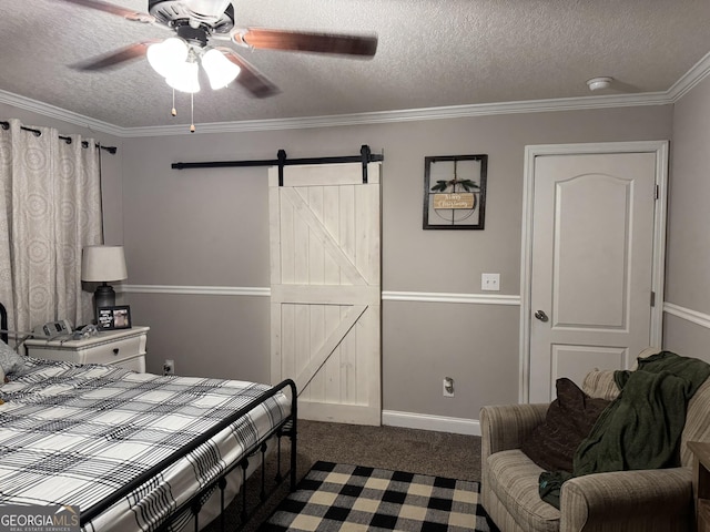 carpeted bedroom with a barn door, ceiling fan, crown molding, and a textured ceiling