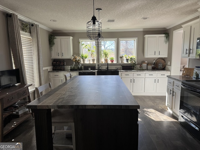 kitchen featuring a kitchen island, white cabinetry, sink, and black electric range