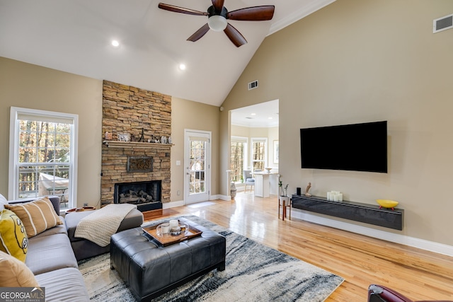 living room featuring a fireplace, hardwood / wood-style flooring, high vaulted ceiling, and ceiling fan