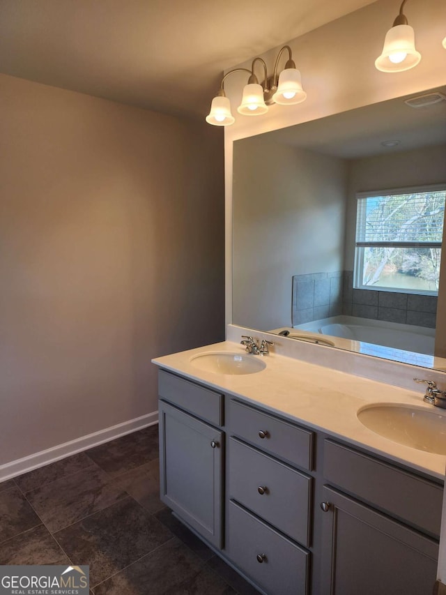 bathroom featuring a bathing tub, vanity, and a chandelier