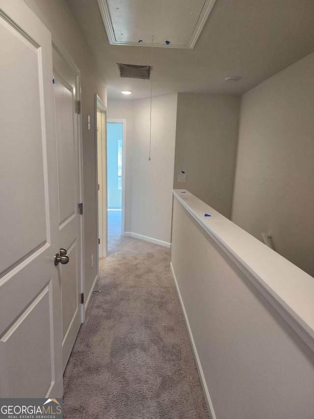 hallway featuring light colored carpet