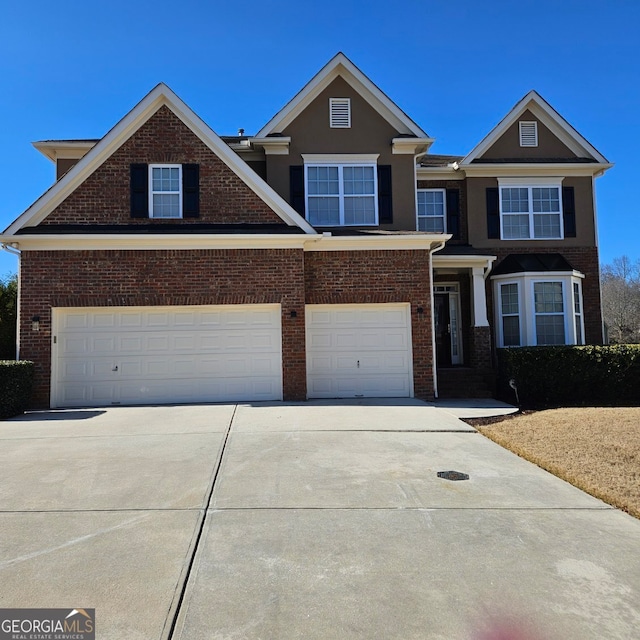 view of front facade with brick siding, driveway, and a garage