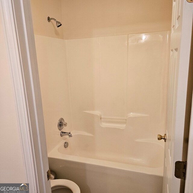 bathroom featuring shower / bathtub combination and toilet