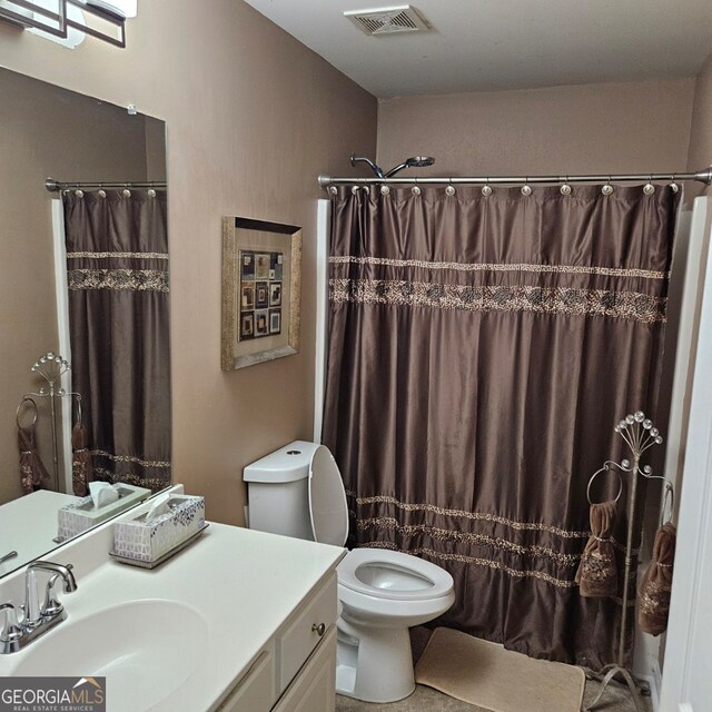 bathroom with a shower with shower curtain, vanity, and toilet