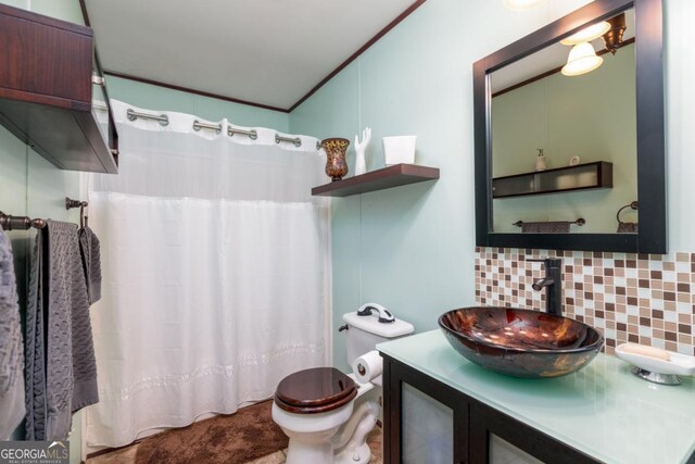 bathroom with decorative backsplash, ornamental molding, vanity, vaulted ceiling, and toilet