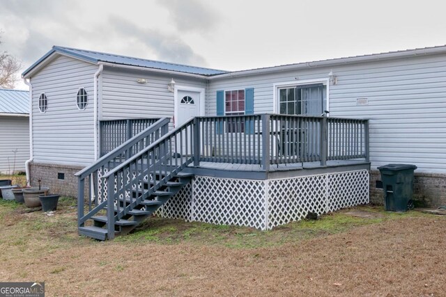 rear view of house featuring a yard and a wooden deck