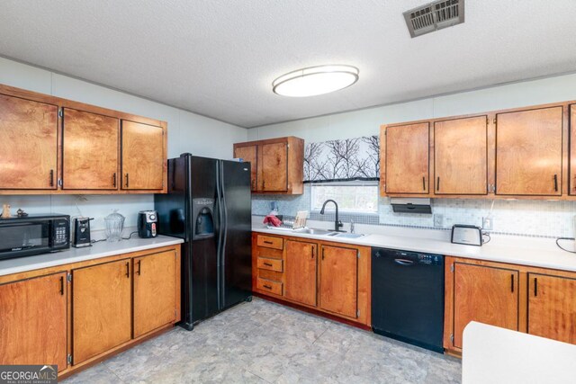 kitchen featuring sink, black appliances, and a textured ceiling