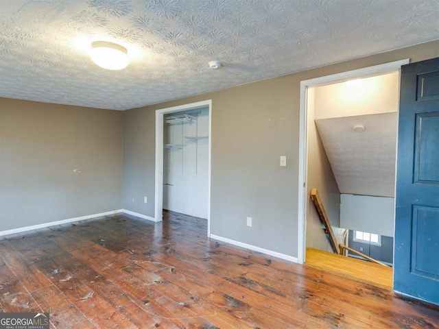 unfurnished bedroom featuring a closet, a textured ceiling, and hardwood / wood-style flooring