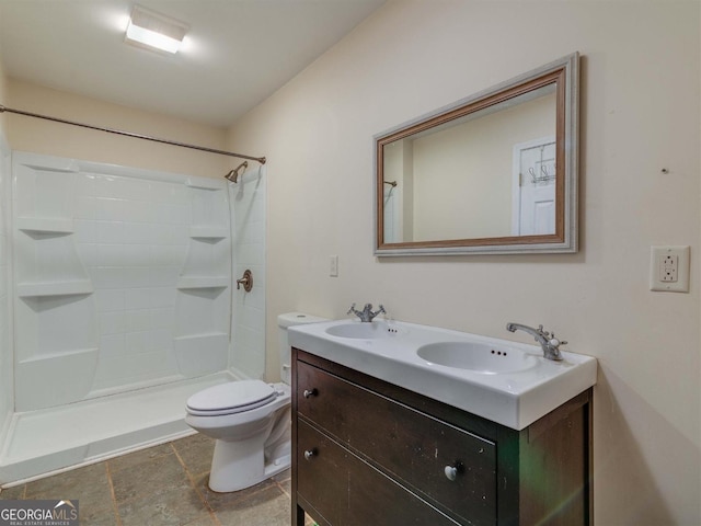 bathroom featuring toilet, walk in shower, and vanity