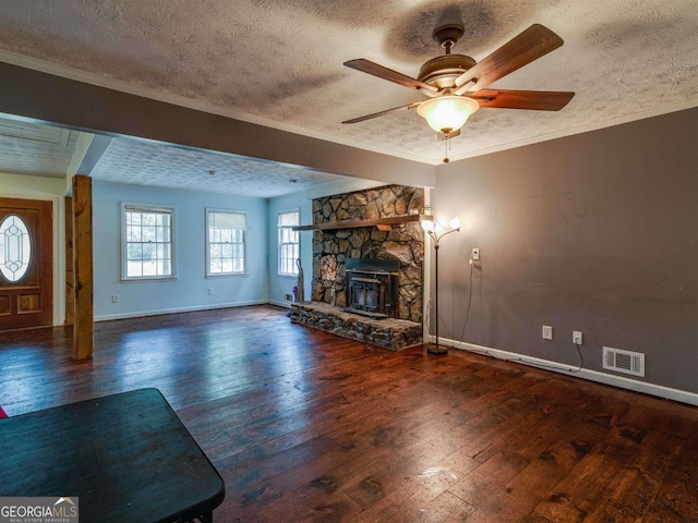 unfurnished living room with ceiling fan, a textured ceiling, dark hardwood / wood-style flooring, and ornamental molding