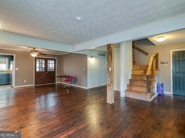 unfurnished living room with ceiling fan, dark hardwood / wood-style floors, sink, a textured ceiling, and french doors