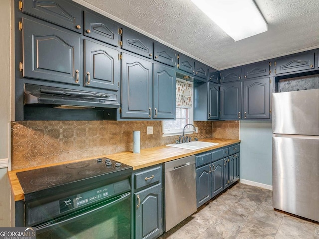 kitchen with backsplash, sink, appliances with stainless steel finishes, a textured ceiling, and wood counters