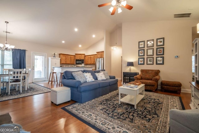 living room with high vaulted ceiling, ceiling fan with notable chandelier, and hardwood / wood-style flooring