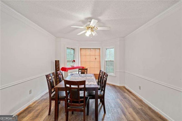 dining room with crown molding, ceiling fan, dark wood-type flooring, and a textured ceiling