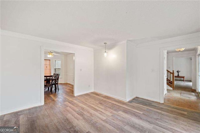 spare room with hardwood / wood-style flooring, ceiling fan, and crown molding