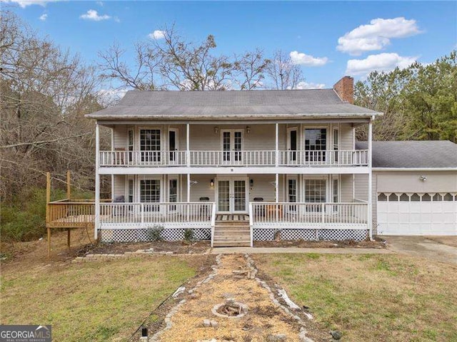 view of front of house featuring french doors, a front lawn, and a garage