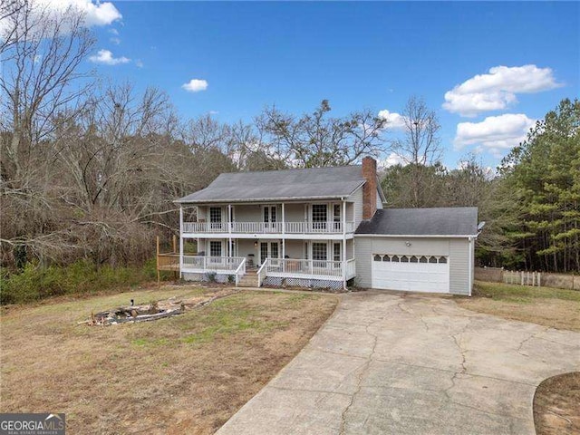 view of front of property with a front lawn, a porch, and a garage