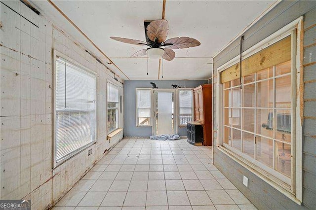 unfurnished sunroom with a wealth of natural light and ceiling fan