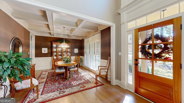 foyer entrance with beam ceiling, plenty of natural light, coffered ceiling, and a notable chandelier