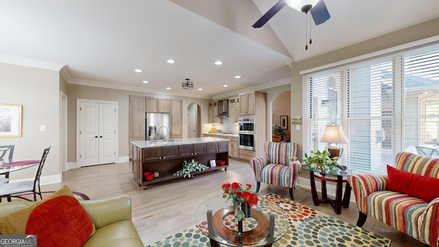 living room with ceiling fan, crown molding, sink, light hardwood / wood-style flooring, and lofted ceiling