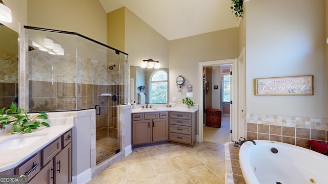 bathroom featuring tile patterned flooring, vanity, independent shower and bath, and high vaulted ceiling