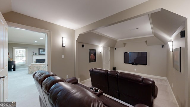 home theater featuring light colored carpet, lofted ceiling, and crown molding