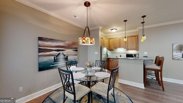 dining area featuring dark hardwood / wood-style floors and crown molding