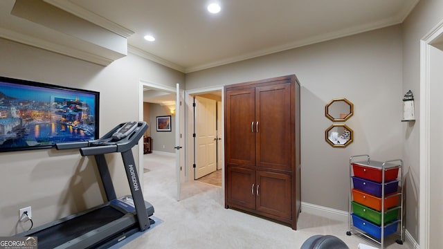 exercise room with light carpet and ornamental molding