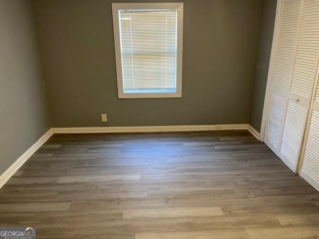 unfurnished bedroom featuring a closet and hardwood / wood-style flooring