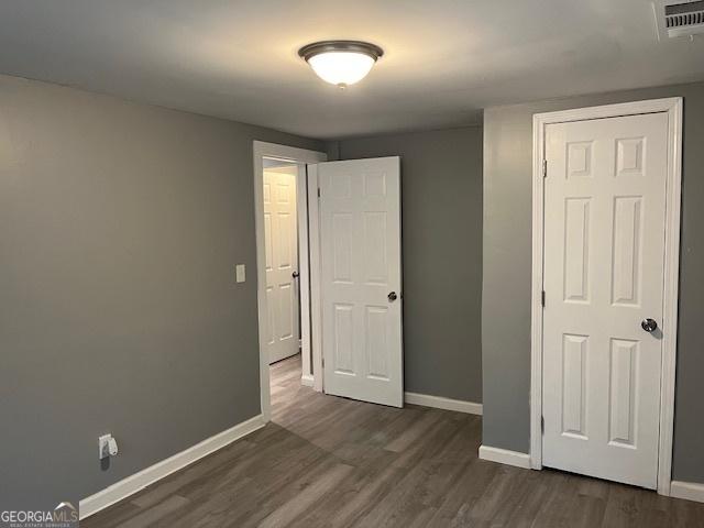 unfurnished bedroom featuring dark hardwood / wood-style flooring