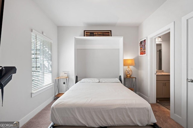 bedroom featuring connected bathroom and carpet