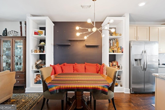 dining area featuring a notable chandelier and dark wood-type flooring