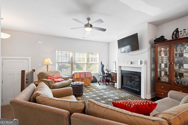 living room with ceiling fan and dark wood-type flooring