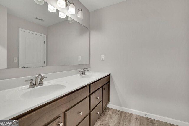 147 Stargaze Rdg, Canton, GA 30114 - full bathroom with wood finished floors, double vanity, a sink, baseboards, and visible vents