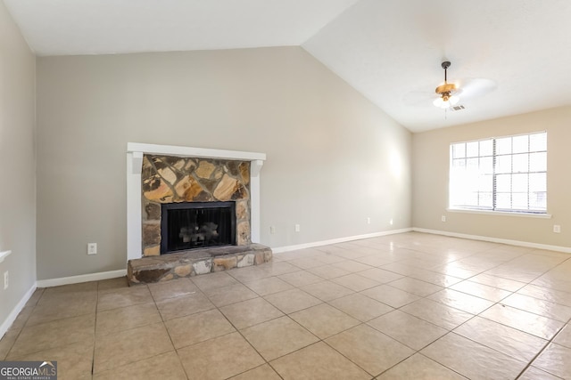 unfurnished living room featuring vaulted ceiling, ceiling fan, a stone fireplace, and light tile patterned flooring