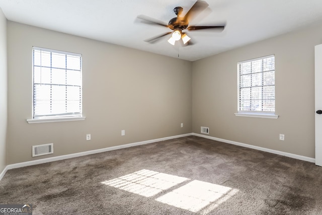 carpeted spare room featuring ceiling fan and a healthy amount of sunlight