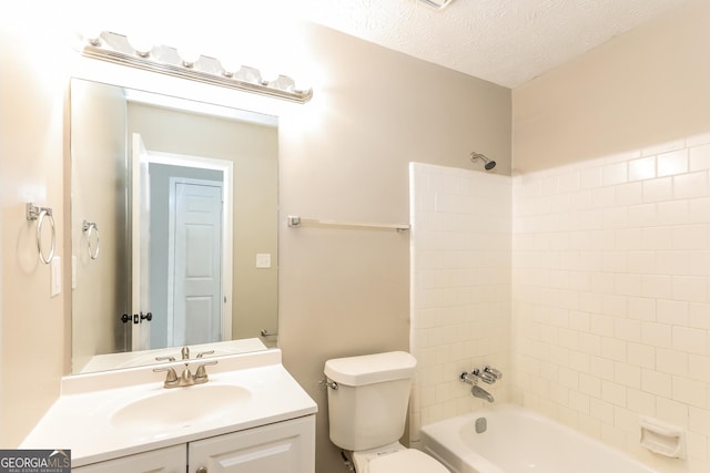 full bathroom featuring vanity, tub / shower combination, toilet, and a textured ceiling